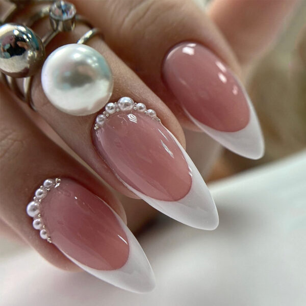 French nails with nude pink almond tips and pearl accents